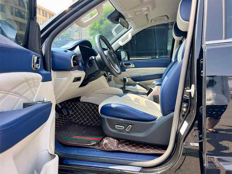 Interior of TUNLAND G9 with leather seats, steering wheel, and floating touchscreen.