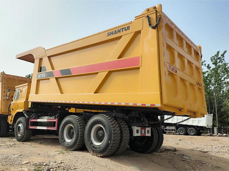 Large capacity dump body of SHANTUI SK105 mining tipper truck for ore and rock transportation.