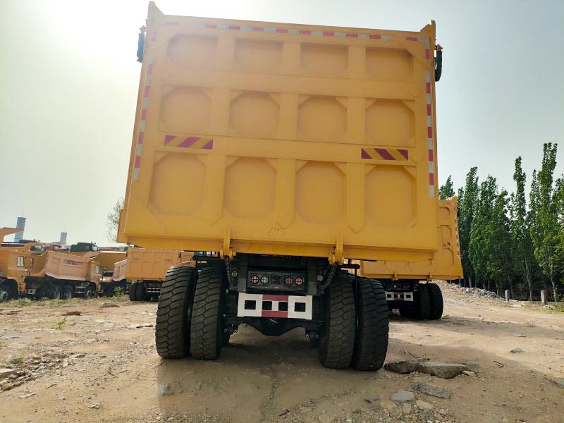 Close-up view of the SHANTUI SK105 dump truck's massive 46m&sup3; heaped capacity cargo box and robust chassis.